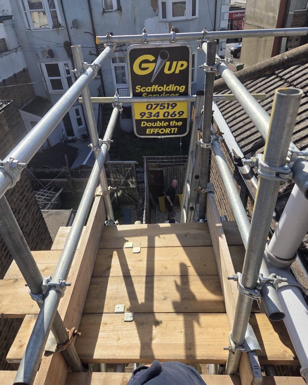 GUP Scaffolding crew working high on a scaffold tower above an Eastbourne terrace